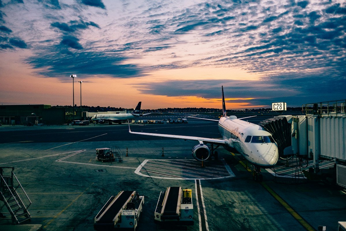 View through an airplane window overlooking coastal clouds and runway approach