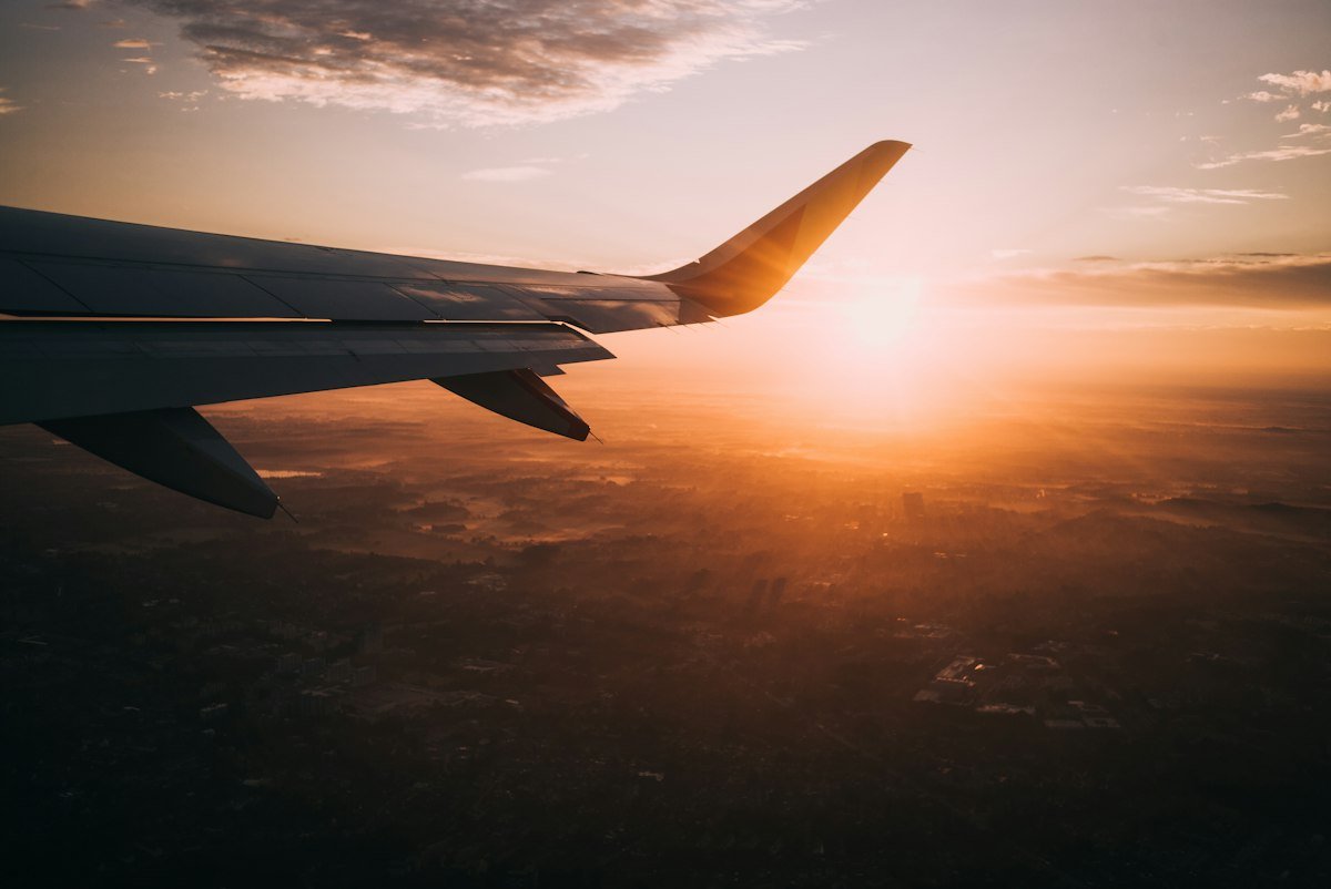 Airplane approaching a mountain valley airport runway at dusk
