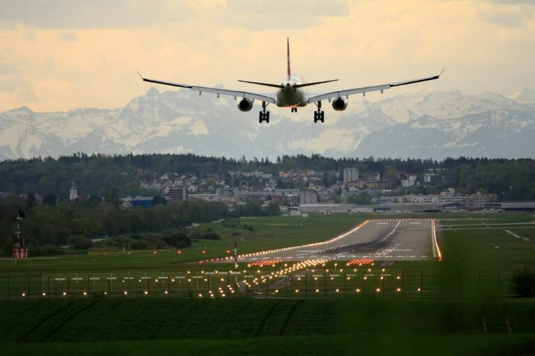 Widebody international passenger aircraft parked at an airport terminal gate at dusk
